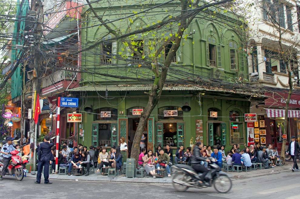 Cafetería en Hanói con gente sentada en la calle cafe de Vietnam