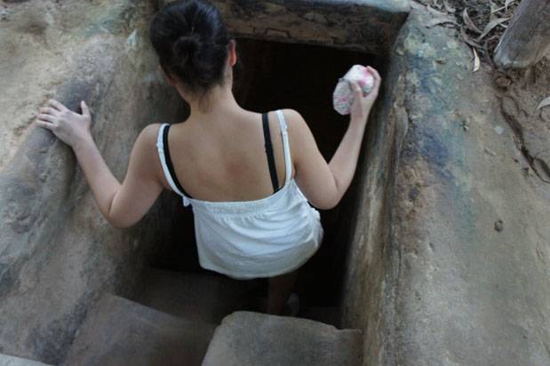turista entrando en el tunel de Cu Chi turista entrando en el tunel