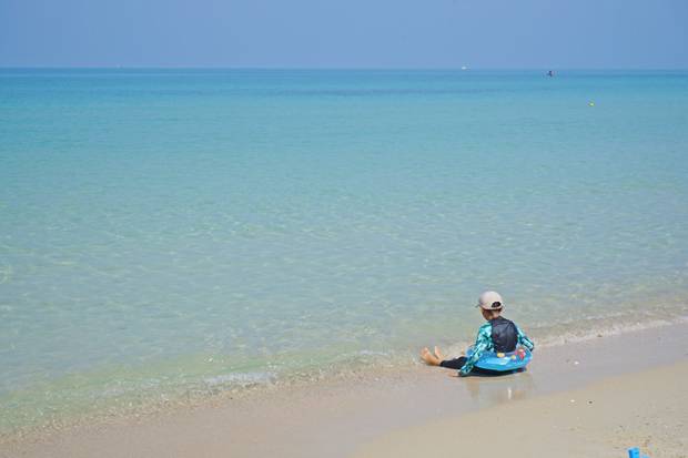 Niñoa en el agua de la playa de Sai Kaew niño en el agua