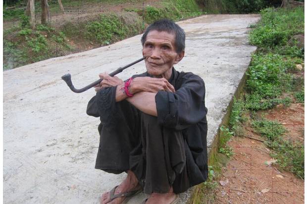 Hombre de tribu fumando opio con pipa Hombre Fumando opio